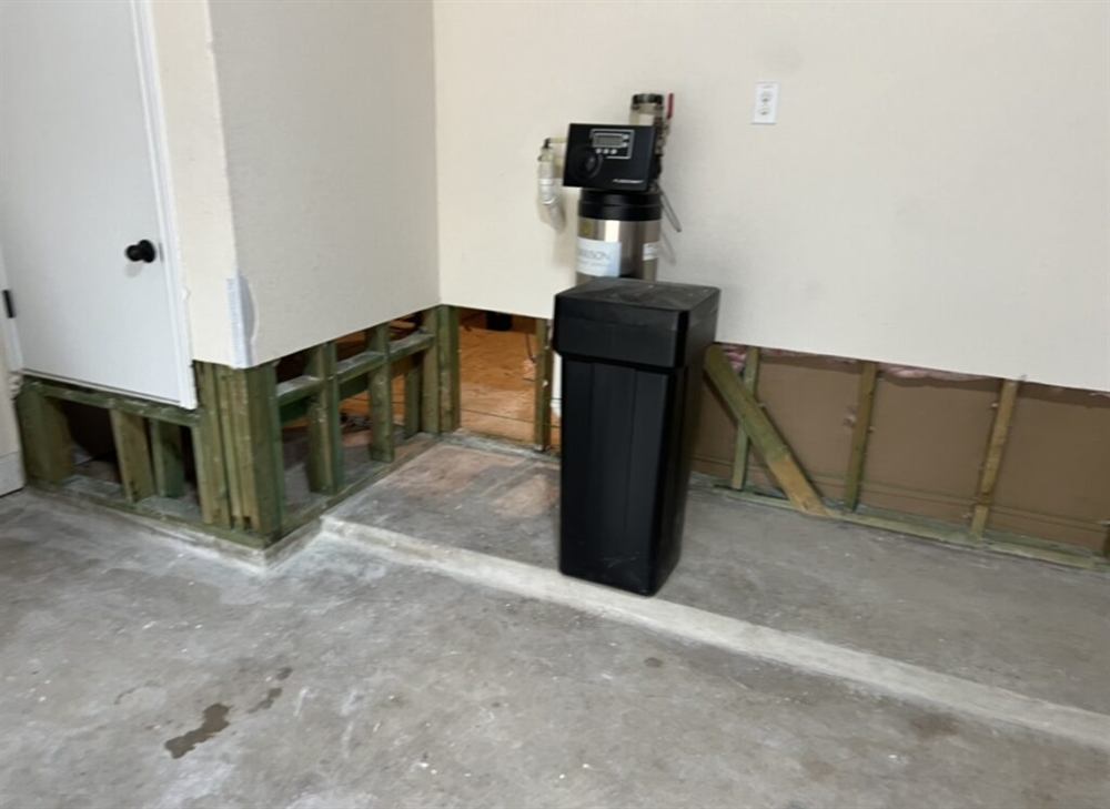 Flood cut with exposed studs after water damage in a San Antonio garage