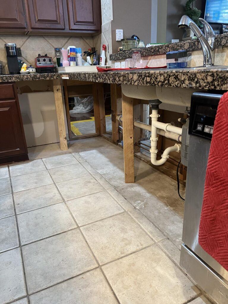 Kitchen cabinets removed with exposed plumbing during water damage restoration in Seguin